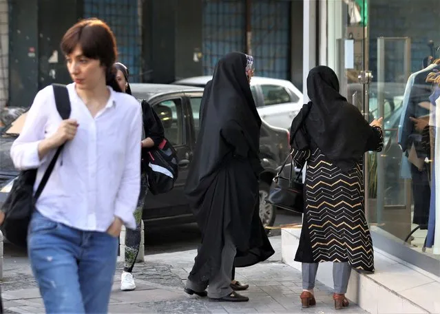 Iranian women walk on a street during the revival of morality police in Tehran, Iran on July 16, 2023. (Photo by Majid Asgaripour/WANA (West Asia News Agency) via Reuters)