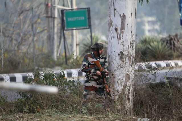 An Indian soldier takes position outside an army camp at Nagrota, in the outskirts of Jammu, India, Tuesday, November 29, 2016. Police said that militants fired indiscriminately and tried to enter an army camp in Nagrota town, triggering a fierce gun battle. (Photo by Channi Anand/AP Photo)