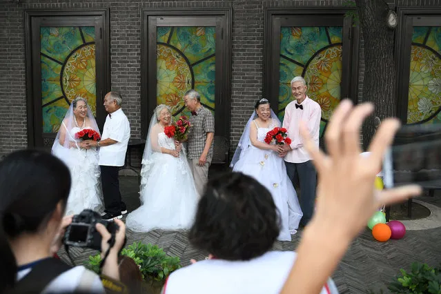 Participants pose at a photo shoot event organized to recreate wedding photos for elderly couples, who have been married for more than 50 years, a day ahead of the Qixi festival, also known as Chinese Valentine's Day, in Tianjin, China on August 16, 2018. (Photo by Tingshu Wang/Reuters)