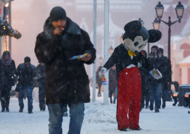 A street performer dressed as Walt Disney character Mickey Mouse distributes leaflets during a heavy snowfall in central Moscow, Russia, December 5, 2016. (Photo by Maxim Shemetov/Reuters)