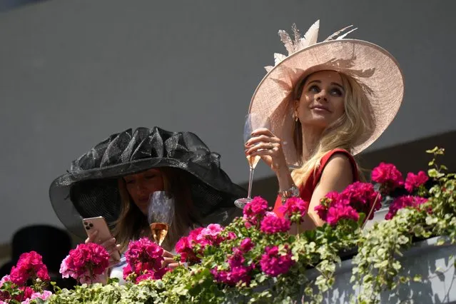 Racegoers wear ornate hats as they look down on the parade ring on the second day of of the Royal Ascot horserace meeting, at Ascot Racecourse, in Ascot, England, Wednesday, June 15, 2022. (Photo by Alastair Grant/AP Photo)