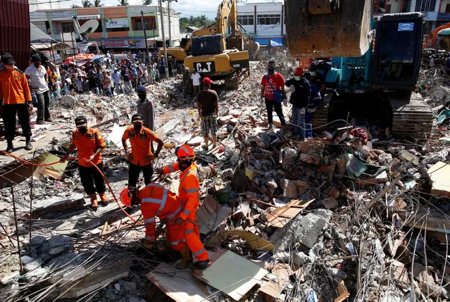 Rescue teams use heavy equipment to dig through a collapsed building following a strong earthquake in Meureudu market,  Pidie Jaya, Aceh province, Indonesia December 8, 2016. (Photo by Darren Whiteside/Reuters)