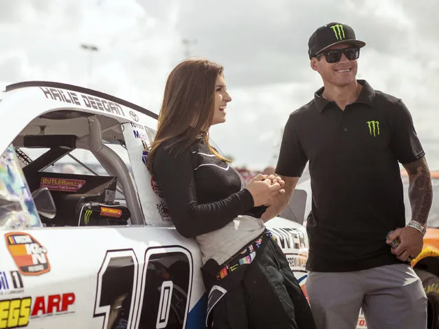 In this file image taken February 11, 2018 and provided by Connexions Sports and Entertainment, NASCAR K&N Pro Series East driver Hailie Deegan shares a laugh with her father Brian Deegan at the New Smyrna Speedway in New Smyrna Beach Fla. On Saturday, Sept. 29, 2018, Seventeen-year-old Deegan used a bump-and-run on her teammate to become the first female winner of a NASCAR K&N West Series race. (Photo by Chris Garrison/Connexions Sports and Entertainment via AP Photo)