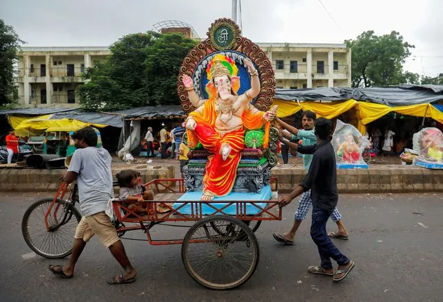 Devotees transport an idol of the Hindu god Ganesh, the deity of prosperity, in a rickshaw to a place of worship on the first day of the ten-day-long Ganesh Chaturthi festival, in Ahmedabad, India on September 19, 2023. (Photo by Amit Dave/Reuters)