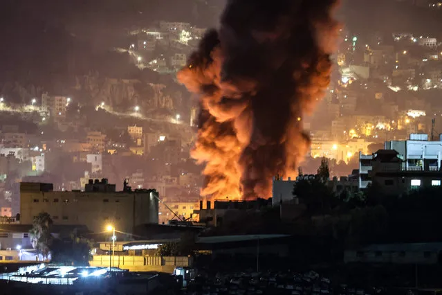 Smoke rises from burning tyres in the eastern area of the occupied West Bank city of Nablus, during clashes between Palestinians and Israeli forces, after the latter entered the city to secure the entry of Jewish worshippers to Joseph's Tomb late on October 4, 2023. (Photo by Zain Jaafar/AFP Photo)