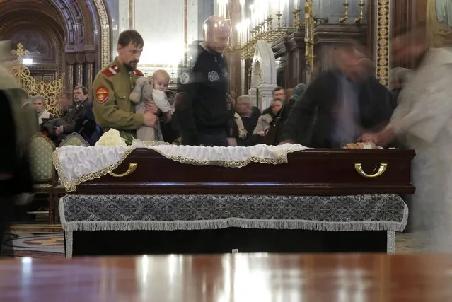People walk past the coffin containing the body of Russian ambassador to Turkey Andrei Karlov, who was shot dead by an off-duty policeman while delivering a speech in an Ankara art gallery on December 19, during a memorial service at the Christ the Savior Cathedral in Moscow, Russia December 22, 2016. (Photo by Maxim Shemetov/Reuters)