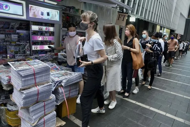 People queue up for last issue of Apple Daily at a newspaper booth at a downtown street in Hong Kong, Thursday, June 24, 2021. Across Hong Kong, people lined up early Thursday to buy the last print edition of the last remaining pro-democracy newspaper. (Photo by Vincent Yu/AP Photo)