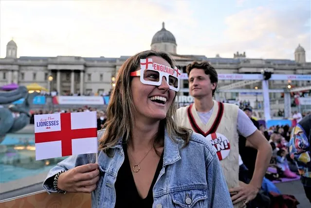 An England supporter smiles as she watches a live screening of the Women's Euro 2022 semifinal soccer match between England and Sweden at the fan area in Trafalgar Square in London, England, Tuesday, July 26, 2022. (Photo by Albert Pezzali/AP Photo/File)