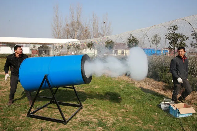 People demonstrate a home-made “smog cannon” which fires cannonballs made of “water and tobacco tar” to remind people the importance of protecting environment, in Xiangyang, Hubei province, December 27, 2016. (Photo by Reuters/Stringer)