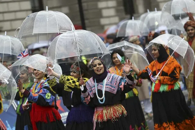 Bolivian performers shelter under umbrellas during the New Year's day parade in London, Britain January 1, 2017. (Photo by Neil Hall/Reuters)