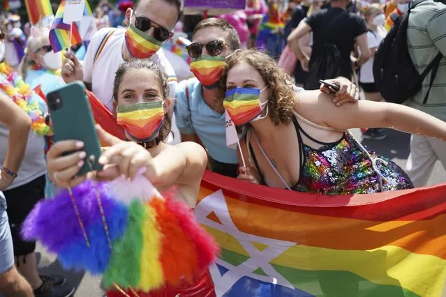 People take part in the Christopher Street Day (CSD) parade, in Berlin, Saturday, July 24, 2021. The official motto of the CSD is “Save our Community – save our Pride”.  (Photo by J'rg Carstensen/dpa via AP Photo)