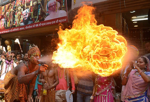 Indian dancers perform a fire breathing act during a procession to mark the 661st anniversary of the birth of Hindu guru Bawa Lal Dayal Maharaj in Amritsar on February 9, 2016. Bawa Lal Dayal Maharaj, a popular leader of his time, is especially revered by devotees of a temple in the town of Dhyanpur, some 45 kms north of Amritsar. (Photo by Narinder Nanu/AFP Photo)