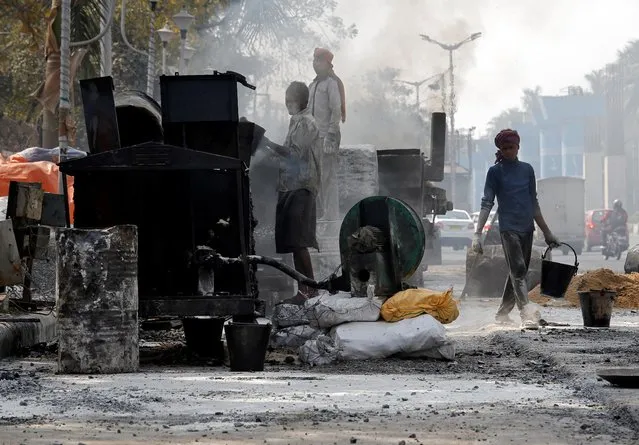 Labourers work at a road construction site on the outskirts of Kolkata, India, February 1, 2019. (Photo by Rupak De Chowdhuri/Reuters)