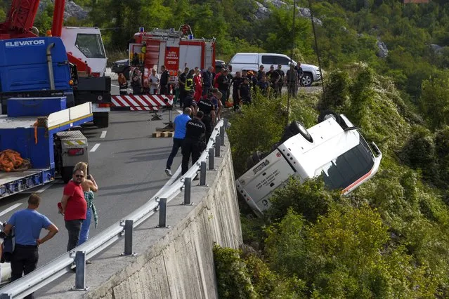 Rescue workers remove a bus at the accident site on a road near Cetinje, Montenegro, Tuesday, September 19, 2023. A British national and another person were killed Tuesday and nine people were seriously injured in Montenegro when a bus plunged into a ravine, authorities said. The bus was carrying some 30 passengers when it swerved on a steep road around noon, police said. (Photo by Risto Bozovic/AP Photo)