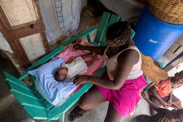 Lovely Jean, 24, looks at her 12 day-old newborn baby, Love Shaiska Alexandre in her house affected by the 7.2 magnitude quake in the Camp Perrin neighborhood in, Les Cayes, Haiti August 22, 2021. (Photo by Ricardo Arduengo/Reuters)