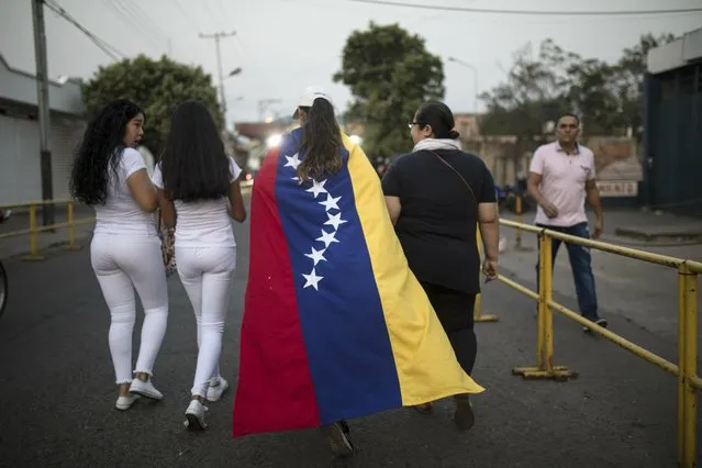 People walk to the Venezuela Aid Live concert that will play on the Colombian side of the border, in Urena, Venezuela, Friday, February 22, 2019. (Photo by Rodrigo Abd/AP Photo)