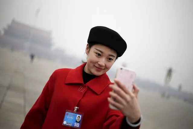 A hostess takes a selfie near the Great Hall of the People before a meeting ahead of Saturday's  opening ceremony of the National People's Congress (NPC), in Beijing, China March 4, 2016. (Photo by Jason Lee/Reuters)