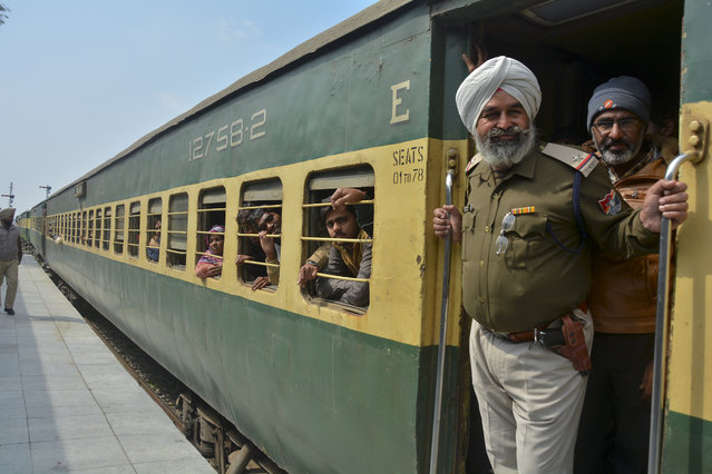An Indian policeman and passengers from Pakistan look on from the Samjhauta Express train as it arrives in Atari, India, Monday, March 4, 2019. A Pakistani railway official said the key train service with neighboring India has resumed in another sign of easing tensions between the two nuclear-armed rivals since a major escalation last week over disputed Kashmir region. (Photo by Prabhjot Gill/AP Photo)