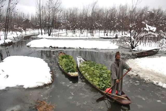 A vegetable seller in semi frozen lake heading towards the main market on January 23, 2014 in Srinagar, India. Kashmir remained cut-off from the rest of the country for the second day on Thursday with road and air links to the Valley snapped due to snowfall, the heaviest in a decade in the month of January. (Photo by Waseem Andrabi/Hindustan Times via Getty Images)