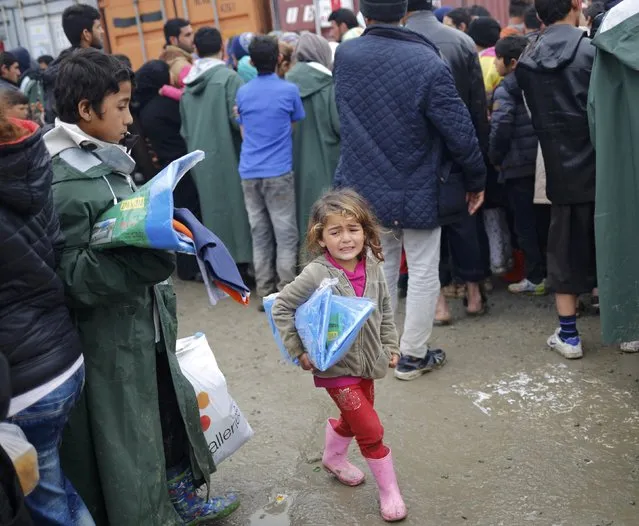 A migrant girl cries as she walks through a makeshift camp on the Greek-Macedonian border near the village of Idomeni, Greece March 10, 2016. (Photo by Stoyan Nenov/Reuters)