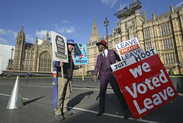 Protestors for opposing views face off against each other, with pro-Brexit split from Europe at right, and pro-Europe anti Brexit at left, outside parliament in London, Monday March 25, 2019. (Photo by Jonathan Brady/PA Wire via AP Photo)