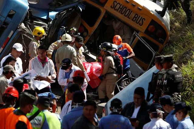Rescue workers and members of the red cross are carrying a body after a crash between a bus and a truck on the outskirts of Tegucigalpa, Honduras, February 5, 2017. (Photo by Jorge Cabrera/Reuters)