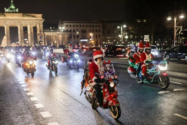 Motorcycle fans dressed as Santa Claus ride along the 17 June street during the 25th annual “Santa Claus On Road” Berlin Bike Tour to deliver gifts to the needy on December 10, 2022 in Berlin, Germany. The annual event attracts about 200 participants. Anyone may ride along, whether on motorcycle, trike or quad, as long as the vehicle is decorated accordingly. (Photo by Omer Messinger/Getty Images)