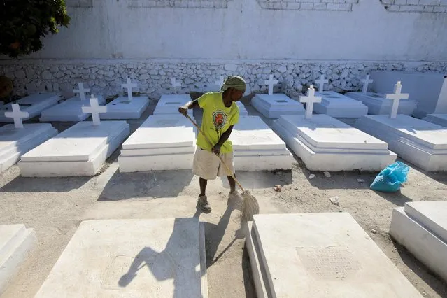 A man sweeps between gravesites at a cemetery during of the Day of the Dead celebrations, in Port-au-Prince, Haiti on November 1, 2021. (Photo by Ralph Tedy Erol/Reuters)