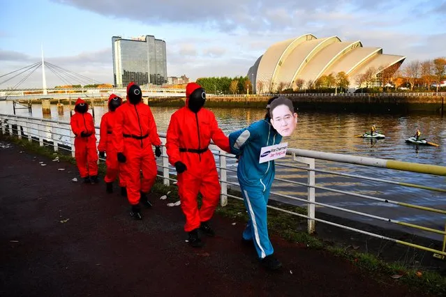Climate activists dressed as characters inspired by the Netflix series “Squid Game” protest as they ask Samsung to go 100% renewable energy, outside the venue for the UN Climate Change Conference (COP26) in Glasgow, Scotland Britain, November 10, 2021. (Photo by Dylan Martinez/Reuters)