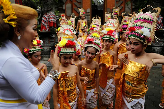 Balinese Hindu girls take a brief before they perfom Rejang Dewa dance during a ritual before the holy day of Nyepi, which is a day of silence for self-reflection to celebrate the Balinese Hindu new year, in Jakarta, Indonesia, March 6, 2019. (Photo by Willy Kurniawan/Reuters)