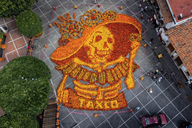 An aerial view of the figure of a Catrina skull made with 18,000 Cempasuchil flowers (Mexican marigold) is on display at the Church of Santa Prisca as part of Day of the Dead celebrations, in Taxco, Mexico on October 27, 2021. (Photo by Daniel Cardenas/Anadolu Agency via Getty Images)