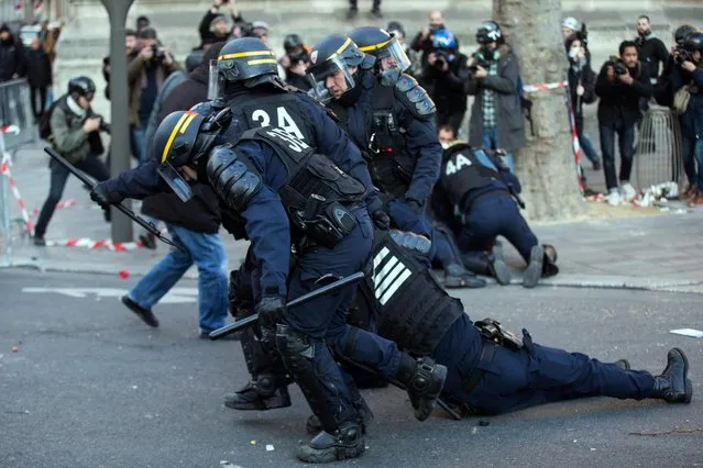 An unconscious riot police officer is dragged by fellow officers after he received a rock on the head, as clashes erupt during a demonstration to support Theo and against police violence in Paris, France, 18 February 2017. Theo, a young man, was hospitalised for an emergency surgery after he was allegedly sodomized with a truncheon during a police check on 02 February 2017. The incident sparked violent protests in the Paris suburb, one police officer is now charged with rape. (Photo by Etienne Laurent/EPA)
