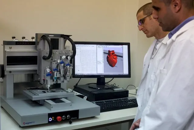 Professor Tal Dvir (R) and a researcher stand next to a 3-D printer during their interview with Reuters about their development of a 3D printed patch comprised of lab-grown heart tissue and nano-electronics that could potentially revolutionize the treatment of heart disease, at a laboratory in Tel Aviv University March 16, 2016. (Photo by Nir Elias/Reuters)