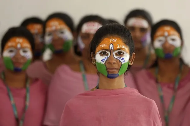School teachers with the colors of the Indian national flag painted on their faces participate in an event to raise awareness among people to vote in the upcoming general elections, in Chennai, India, Thursday, March 28, 2024. (Photo by R. Parthibhan/AP Photo)