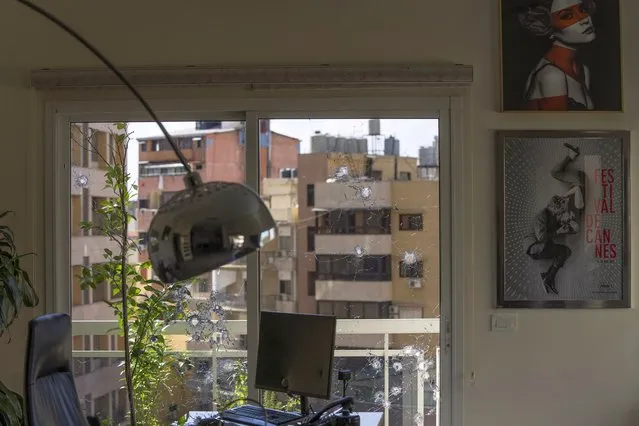 An office window is riddled with bullet holes after the deadly clashes that erupted last Thursday along a former 1975-90 civil war front-line between Muslim Shiite and Christian areas, in Ain el-Rumaneh neighborhood, Beirut, Lebanon, Tuesday, October 19, 2021. The shootout on the streets of Beirut between rival Christian and Muslim groups has revived memories of the country's 1975-90 civil war and fired up sectarian passions in a country that never dealt with the causes of its violent past. (Photo by Hassan Ammar/AP Photo)