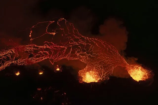 Lava flows from the volcano near the town of Grindavik, Iceland, early Monday, March 25, 2024. The volcano in southwestern Iceland that erupted three times in December, January and February, sending lava towards a nearby community, keeps erupting. (Photo by Marco di Marco/AP Photo)