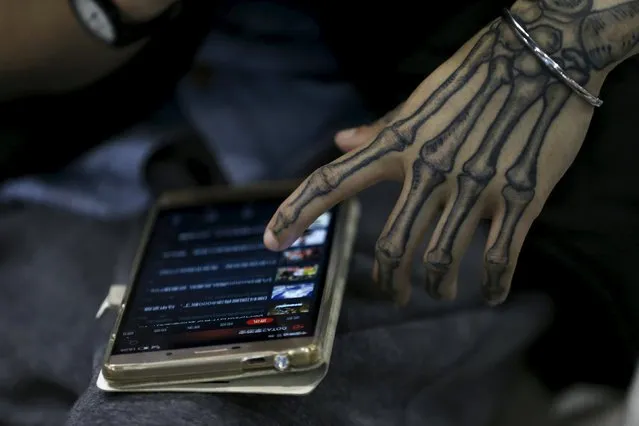An exhibitor checks his phone during an exhibition of 2016 Shanghai International Art Festival Of Tattoos in Shanghai, China, April 23, 2016. (Photo by Aly Song/Reuters)