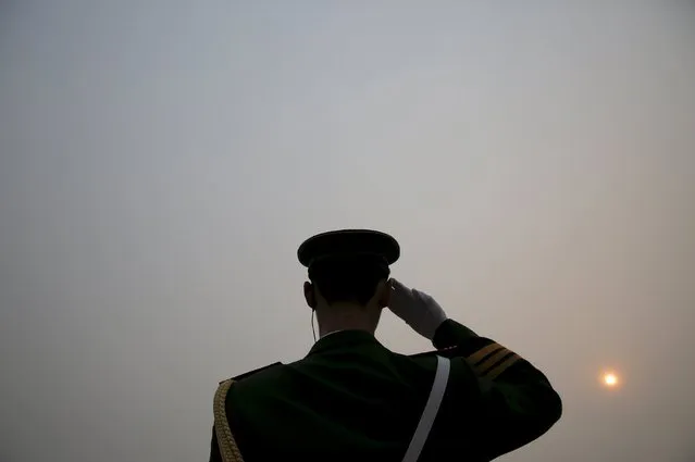 The sun is seen through smog on a severely polluted day as a paramilitary policeman salutes to delegates arriving at the Great Hall of the People before the opening ceremony of the National People's Congress (NPC) in Beijing, China, March 4, 2016. (Photo by Damir Sagolj/Reuters)