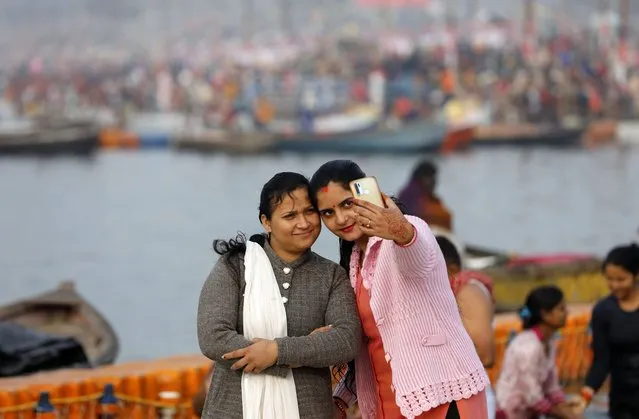Hindu devotees takes a selfie after taking a holy dip in the Sangam, the confluence of three rivers – the Ganges, the Yamuna and the mythical Saraswati, to take a ritualistic bath during Makar Sankranti festival that falls during the annual traditional fair of Magh Mela festival, one of the most sacred pilgrimages in Hinduism, in Prayagraj, India. Friday, January 14, 2022. (Photo by Rajesh Kumar Singh/AP Photo)