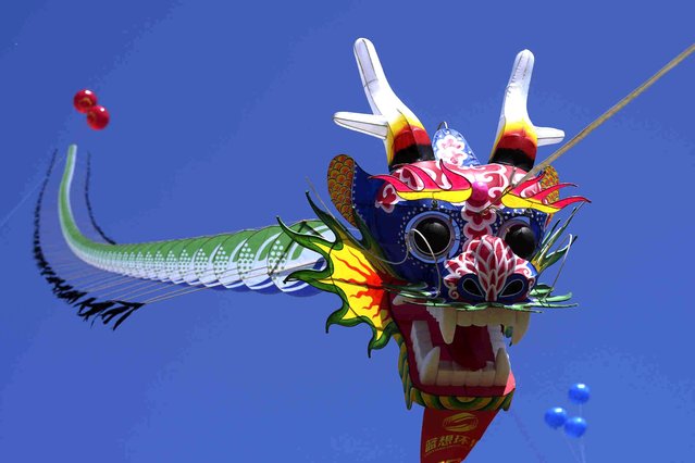 A dragon-shaped kite flies in the air at the 41st International Kite Festival in Weifang, Shandong Province of China, Saturday, April 20, 2024. (Photo by Tatan Syuflana/AP Photo)