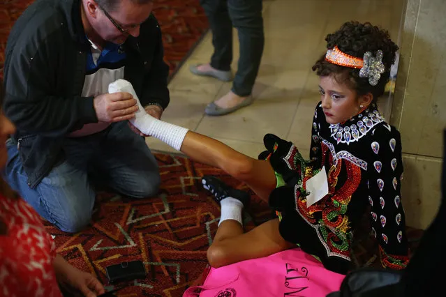 A competitor has her foot massaged by her father before performing at the World Irish Dance Championship on April 13, 2014 in London, England. The 44th World Irish Dance Championship is currently running at London's Hilton London Metropole hotel, and will host approximately 5,000 dancers competing in solo, Ceili, modern figure choreography and dance drama categories during the week long event. (Photo by Dan Kitwood/Getty Images)