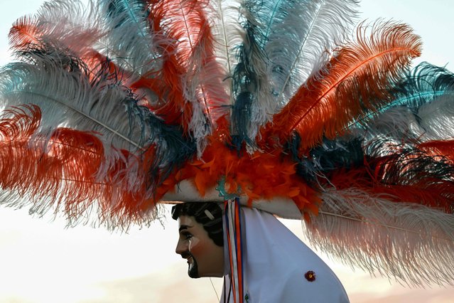 A man wears a typical “huehue” costume while taking part in the carnival of “Los huehues madrugadores” (The early riser huehues) in Totolac municipality, Tlaxcala state, Mexico, on February 26, 2023. (Photo by Pedro Pardo/AFP Photo)