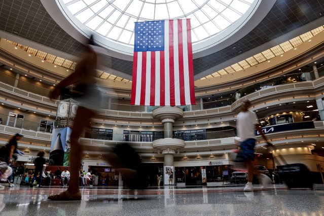 A US flag hangs in the main atrium as passengers navigate through the Fourth Of July holiday travel rush at Hartsfield-Jackson Atlanta International Airport in Atlanta, Georgia, USA, 02 July 2024. Airport officials expect to handle nearly four million passengers through the Independence Day holiday period ending 08 July. (Photo by Erik S. Lesser/EPA)