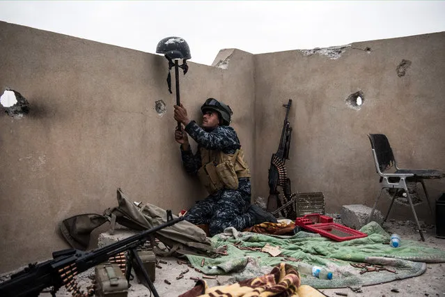 An Iraqi federal policeman uses a helmet on a stick to try and draw fire from an Islamic State sniper in an attempt to make him reveal his position during the battle to recapture west Mosul on April 13, 2017 in Mosul, Iraq. Despite being completely surrounded, Islamic State fighters are continuing to put up stiff resistance to Iraqi forces who are now having to engage I.S in house to house fighting as they continue their battle to retake Iraq's second largest city of Mosul. (Photo by Carl Court/Getty Images)
