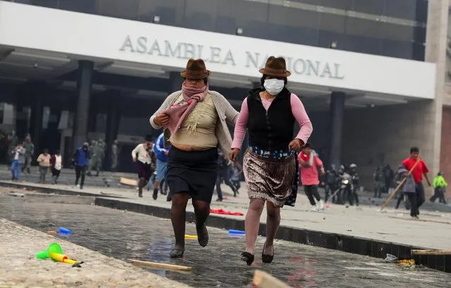 Demonstrators run at the entrance of the National Assembly building, during a protest against Ecuador's President Lenin Moreno's austerity measures in Quito, Ecuador, October 8, 2019. (Photo by Ivan Alvarado/Reuters)