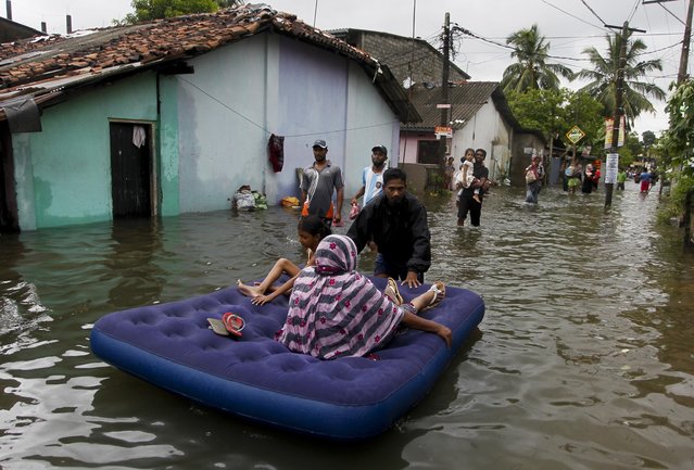 An elderly Sri Lankan woman and a girl are shifted on a mattress at a flooded area in Colombo, Sri Lanka, Tuesday, May 17, 2016. (Photo by Eranga Jayawardena/AP Photo)