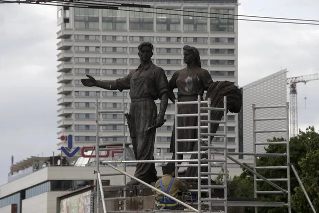 A worker prepares Soviet-time statues for dismantling in Vilnius, Lithuania, July 20, 2015. Workers started dismantling monumental statues of soldiers, students, labourers and farmers in Lithuania's capital early on Monday, the last major Soviet artworks in a city now on the eastern frontier of the European Union and NATO.  (Photo by Ints Kalnins/Reuters)
