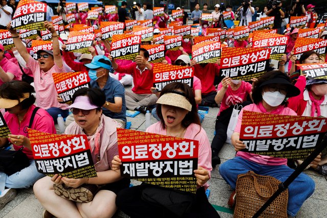 Protesters hold placards during a rally against prolonged doctors' strike in response to the government's plans to increase medical school admissions in Seoul, South Korea, on July 4, 2024. The banner reads, “Get healthcare back on track and create the Doctors Strike Never Again Act”. (Photo by Kim Soo-hyeon/Reuters)