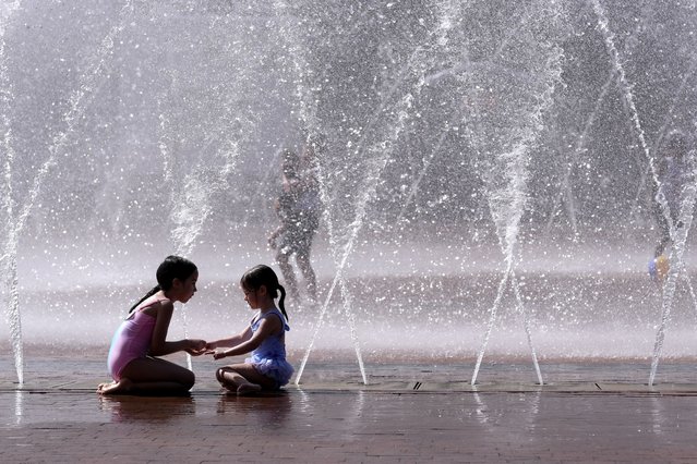 Children play near a splash fountain on the Christian Science Plaza, Sunday, July 7, 2024, in Boston. Temperatures rose into the 90s in some areas in Massachusetts Sunday. (Photo by Steven Senne/AP Photo)