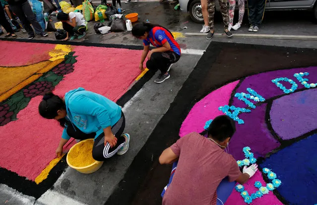 People prepare a sawdust and flower carpet during the feast of Corpus Christi in downtown Trujillo, Peru, May 26, 2016. (Photo by Mariana Bazo/Reuters)